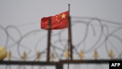 资料照片:新疆喀什南部地区一个院落挂出的中国国旗(2019年6月4日)