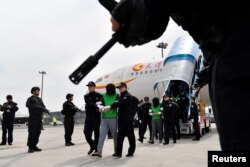中国警察在天津机场押送一批从菲律宾遣返的台湾籍电信诈骗嫌疑人。(2018年4月4日)