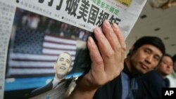 北京有人阅读环球时报关于美国总统奥巴马的文章,头条文章提到世界面临更多不确定(2008年6月5日)环球时报近日主办了主题为“世界纠结,中国求索”的年会。