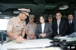 台湾总统蔡英文(中左)登上台湾海军军舰,在军舰出发前往南中国海巡逻前,视察海事表。