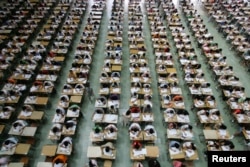 广东东莞理工学院的学生在大厅里参加英语考试,以防作弊(2007年7月9日)