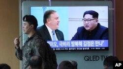 一名韩国军人在首尔火车站走过正在播放蓬佩奥会见金正恩的电视画面。(2018年4月18日)