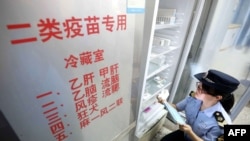 2018年7月23日,当地市场监管机构官员在中国广西荣安一家医院检查疫苗。