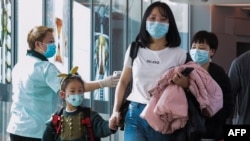 资料照:2020年1月22日卫生人员在新加坡樟宜国际机场检测中国旅客的体温。