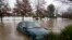 Sebuah mobil terendam air banjir di Camden, pinggiran Sydney, Australia, Senin, 4 Juli 2022. (Foto: Ilustrasi/AP)