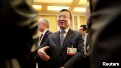 在北京钓鱼台国宾馆举行的中国发展论坛(CDF)年会上,中国商务部副部长兼国际贸易谈判副代表王受文发表演讲后与与会者聊天(2018年3月25日)。