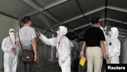 人们在进入广交会会场前接受体温检查,以防埃博拉(2014年10月23日)