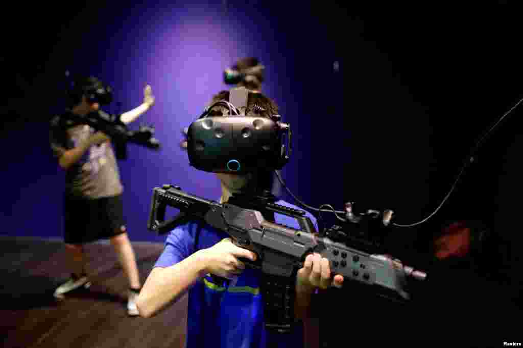 2010年8月1日,台北,在台湾第一家 Viveland VR 虚拟实境乐园,孩子们戴着 HTC Vive Virtual Reality(VR)头盔和眼镜玩耍。
