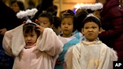 孩子们扮演成天使在官方天主教会的北京南堂参加圣诞前夜的弥撒。(2015年12月24日)