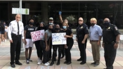 在首都华盛顿近郊马里兰州洛克维尔市举行的反警察暴力集会上,警察负责人与抗议者友好合影。(2020年6月5日)