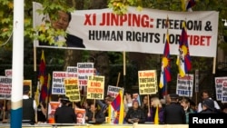 在中国国家主席习近平与英国女王乘坐皇家马车前往白金汉宫的道路旁,人权活动人士举标语牌抗议中国人权 (2015年10月20日)