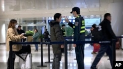 中国湖北省武汉市天河国际机场工作人员测试旅客的体温。(2020年1月21日)