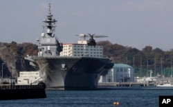 在日本横须贺,一架直升机准备降落在日本海上自卫队“出云”号直升机驱逐舰的飞行甲板上。(2016年12月6日)
