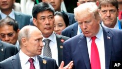 美国总统川普和俄罗斯总统普京在越南参加亚太经合会领导人会议的集体合影期间交谈。(2017年11月11日)