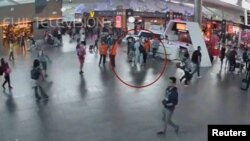 吉隆坡国际机场的监控录像显示一名据信是金正男的男子(圆圈内)在与机场工作人员交谈。(2017年2月13日)
