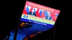北京一家商场外的巨型屏幕上播放中国领导人习近平与俄罗斯总统普京举行在线峰会的新闻。(2021年12月15日)