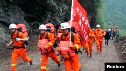 2013年4月21日,在一次地震袭击四川雅安地区的第二天,救援人员快速通过瓦砾抵达被孤立的宝兴县灾区。