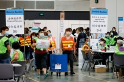 香港选举人员在为选举委员会举行投票后在点票中心交付投票箱。 (2021年9月19日)