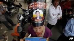 柬埔寨救国党支持者戴着有党主席肯素卡形象的帽子在柬埔寨最高法院外抗议。(2017年10月31日)