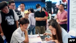 资料照片:2023年8月10日,在中国湖北省武汉,大学毕业生参加一场工作招聘会。