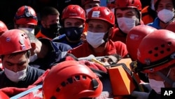 10月31日,伊兹密尔市的救援人员一个从倒塌楼房中救出的受伤的人抬上救护车。