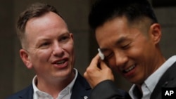 喜极而泣的香港移民官梁镇罡和他的英籍同性婚姻配偶史葛在香港终审法院外接受媒体采访。(2019年6月6日)