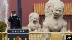 资料照:一名中国警察站在北京天安门前的石狮子旁。(2021年3月11日)