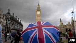 英国全民公决投票脱欧后的一天阴雨绵绵,一个人打着伞走向英国议会大厦。(2016年6月25日)