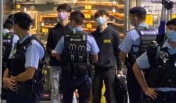 贤学思政召集人王逸战(蓝色口罩者)等4名成员以及3名市民共7人,被警察截查后被拘捕,12月1日凌晨全部获准保释。 (美国之音特约记者汤惠芸摄)