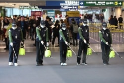 韩国仁川国际机场的工人为防范新型冠状病毒入侵在海关处喷洒消毒药水。(2020年1月21日)
