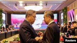 韩国外交部长朴振(左)在印尼雅加达出席东盟外长会议期间与中国最高外交官、中央外办主任王毅会面。(路透社)