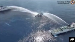 菲律宾海岸警卫队船只(中)2024年4月30 日在斯卡伯勒浅滩(Scarborough Shoal,中国称黄岩岛)遭中国海警船用水炮攻击。