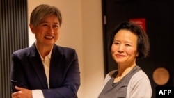 澳大利亚籍华裔记者成蕾(右)被中国当局拘留3年多后获释,2023年10月11日返回墨尔本,在机场受到外交部长黄英贤(Penny Wong)的迎接。(澳大利亚外交部提供)