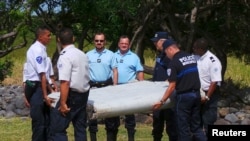 法国航空专家与警方抬起在一个法属印度洋岛屿上发现的一块飞机残骸 (2015年7月29日)