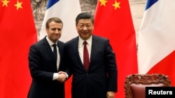 法国总统马克龙与中国国家主席习近平在北京举行联合记者会后握手。(2017年1月9日)