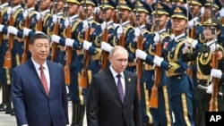 资料照片:2024年5月16日,中国国家主席习近平(左)和俄罗斯总统弗拉基米尔·普京在中国北京举行的官方欢迎仪式上检阅仪仗队。