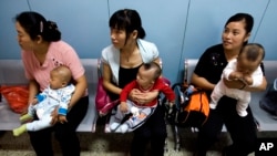 在为农民工提供母婴检查的北京朝阳区十八里店乡医院,中国妇女抱着孩子等着看医生。(2007年9月5日资料照)