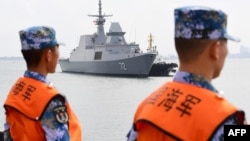 一艘新加坡海军舰艇抵达中国南部广东省湛江市的一个军事港口时,中国水手在一旁观看。(2018年10月21日)