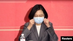 资料照:台湾总统蔡英文在台北出席会议期间整理口罩以防新冠感染。(2020年8月19日)