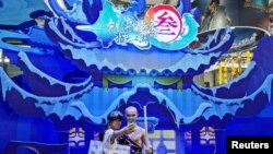 中国国际数码互动娱乐展览会在上海举办期间一名女子与腾讯游戏出品的一款电子游戏中的一角色扮演者合影。(2019年8月2日)