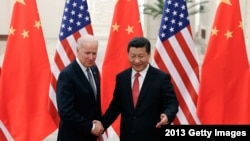 资料照:2013年12月4日中国国家主席习近平与来访的美国副总统拜登握手