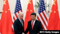 在这张摄于2013年12月4日的档案照中,中国国家主席习近平与当时的美国副总统拜登在北京的人民大会堂握手。