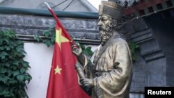 2018年9月29日,在北京的一个政府认可的天主教堂“南堂”入口处,有该教堂的第一个建造者——明代的意大利耶稣会士利玛窦(Matteo Ricci)雕像,旁边有中国国旗。
