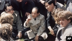历史照片:中国共产党领导人胡耀邦在英国莎士比亚的出生地同英国女学生坐在草地上交谈。(1986年6月10日)