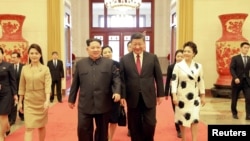 中国国家主席习近平和夫人彭丽媛,朝鲜国务委员会委员长金正恩和夫人李雪主在北京(2018年3月28日发布的照片)。