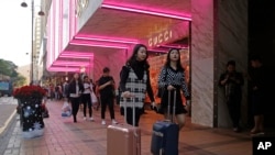 资料照:2018年11月29日,中国游客行走在香港高端品牌一站式购物街广东道(美联社)。