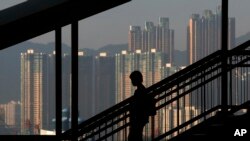 一位女士沿步道而下,背景是香港的摩天大楼。(资料照)