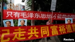 资料照:中国毛派人士手举毛泽东画像和标语横幅在广州南方周末报社外举行抗议集会。(2013年1月9日)