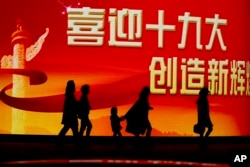 北京居民走过迎接中共十九大召开的大型电子屏幕。(2017年10月15日)