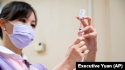 台湾行政院发布的照片显示一名台湾医护人员正在准备注射阿斯利康新冠疫苗。(2021年3月22日)